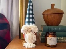 A no-carve pumpkin gnome with yarn eyebrows and  beard and plaid hat